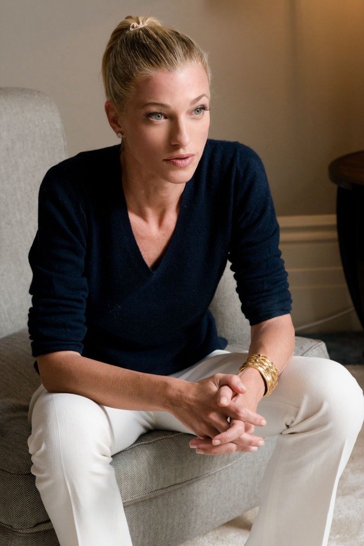 Nicole Junkerman seated calmly with hands clasped, in a warm, softly lit room